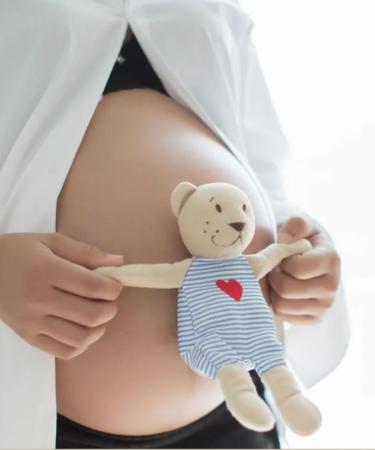 mujer embarazada con osito de peluche