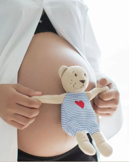 mujer embarazada con osito de peluche